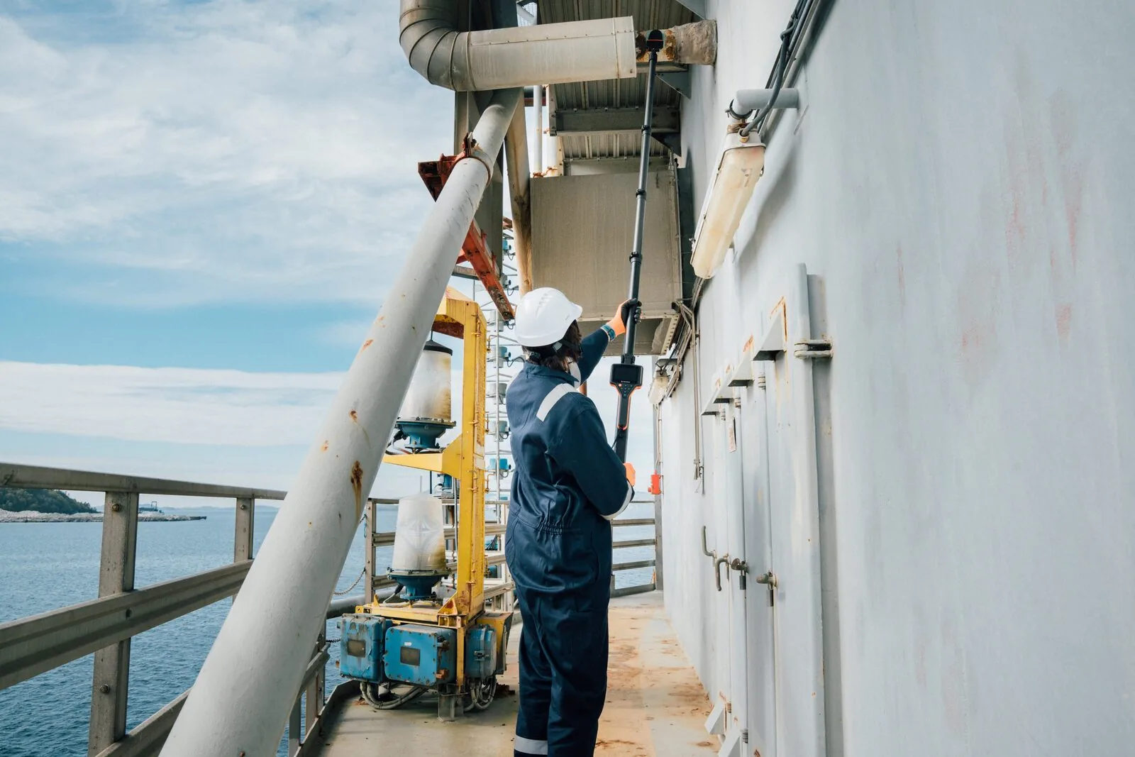 Inspetora utilizando coletor WAND com extensor REACH em plataforma offshore
